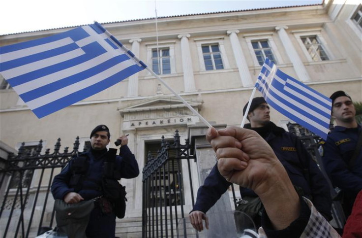 A protester holds Greek flags during a demonstration against a new property tax which has been included to the Greece&#039;s PPC bill to consumers in Athens