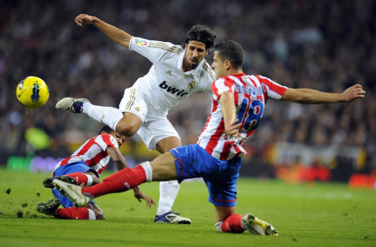 Real Madrid&#039;s Sami Khedira fights for the ball with Atletico Madrid&#039;s Alvaro Dominguez during their first division soccer match at Santiago Bernabeu stadium in Madrid