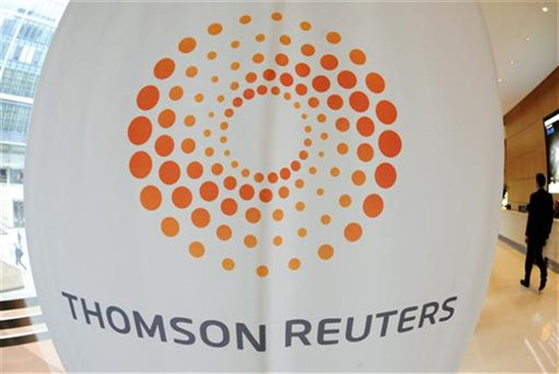 A man walks near a Thomson Reuters logo at the Thomson Reuters building in Canary Wharf in east London