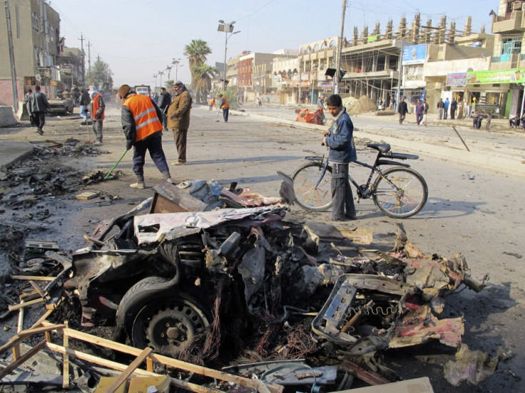 A boy stands near the site of a car bomb attack in Baghdad's Shaab District, northern Baghdad