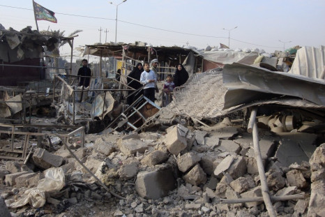 Residents sift throuigh rubble after of a market was bombed in Baghdad's Shula district in northwestern Baghdad