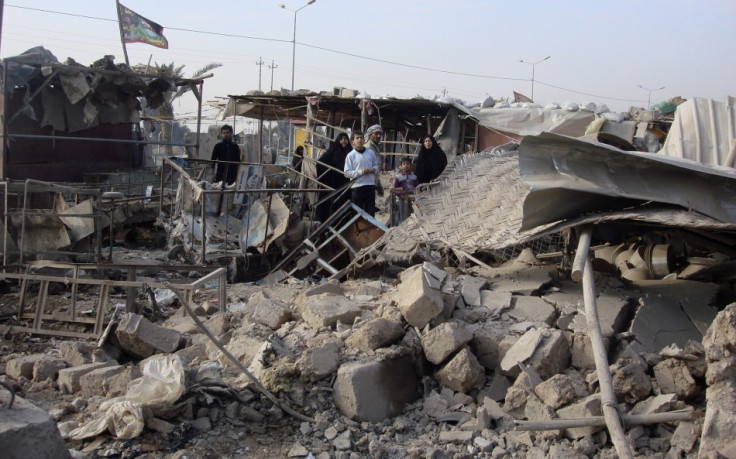 Residents sift throuigh rubble after of a market was bombed in Baghdad's Shula district in northwestern Baghdad