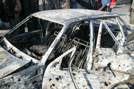 A damaged car is seen where a bomb blew up at security sites in Damascus
