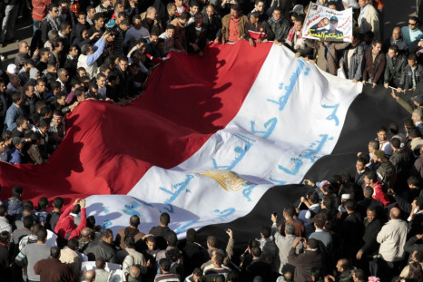 Egyptian protesters shout anti-military council slogans as they hold a national flag in Cairo