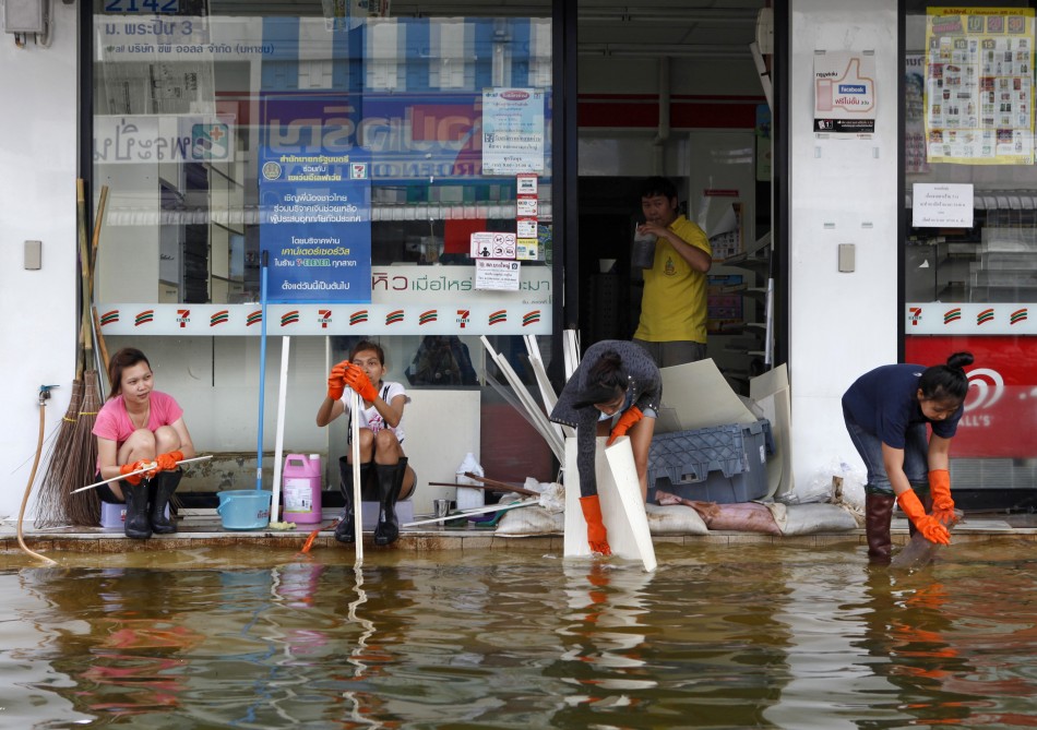 Workers clean a shop as floodwaters recede in Nonthaburi province