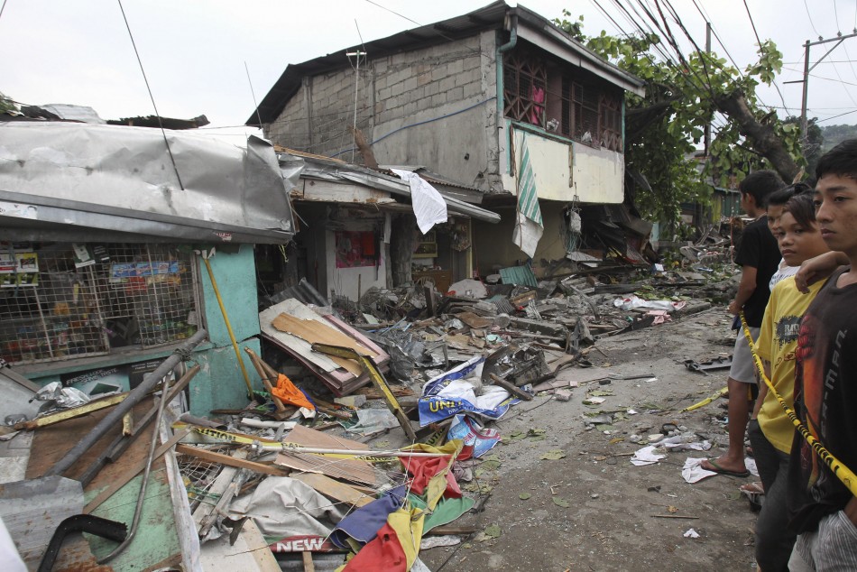 Residents look at the damaged houses after an 18-wheeler truck rammed into a row of houses in Antipolo city