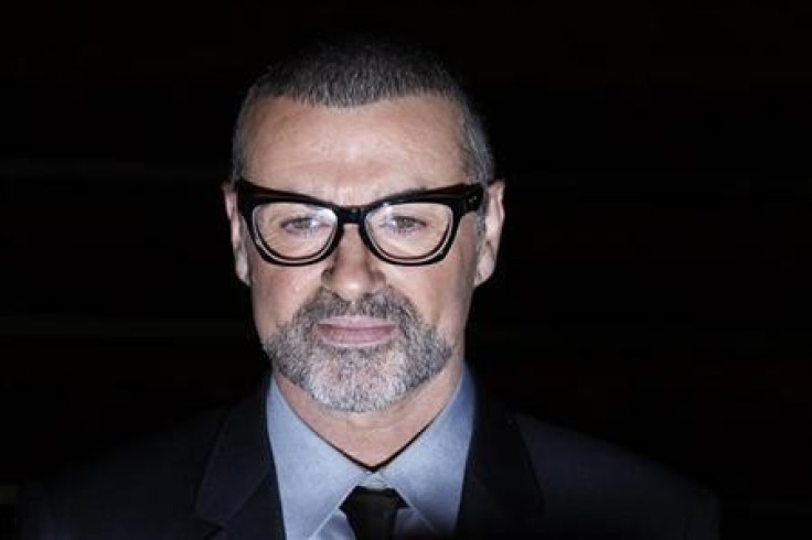 British singer George Michael poses for photographers before a news conference at the Royal Opera House in central