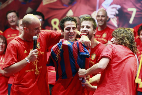 Spain&#039;s Pepe Reina and Carles Puyol put a Barcelona shirt on team-mate Cesc Fabregas as they celebrate their victory in Madrid