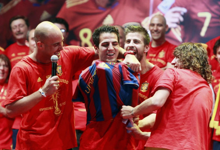 Spain&#039;s Pepe Reina and Carles Puyol put a Barcelona shirt on team-mate Cesc Fabregas as they celebrate their victory in Madrid