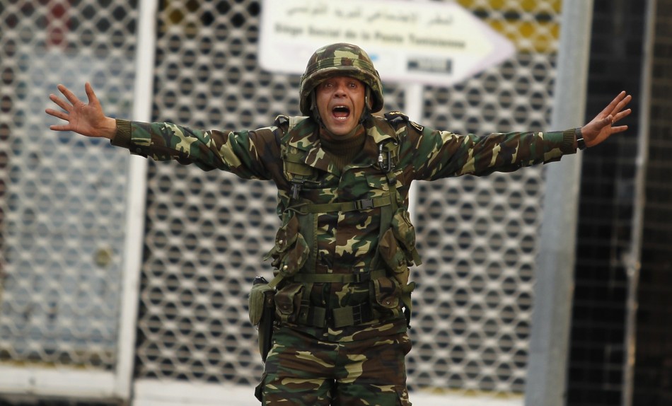 A Tunisian soldier screams to calm protesters