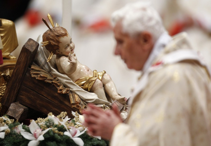 Pope Benedict XVI walks past a figurine of baby Jesus as he leads the Christmas mass in Saint Peter's Basilica