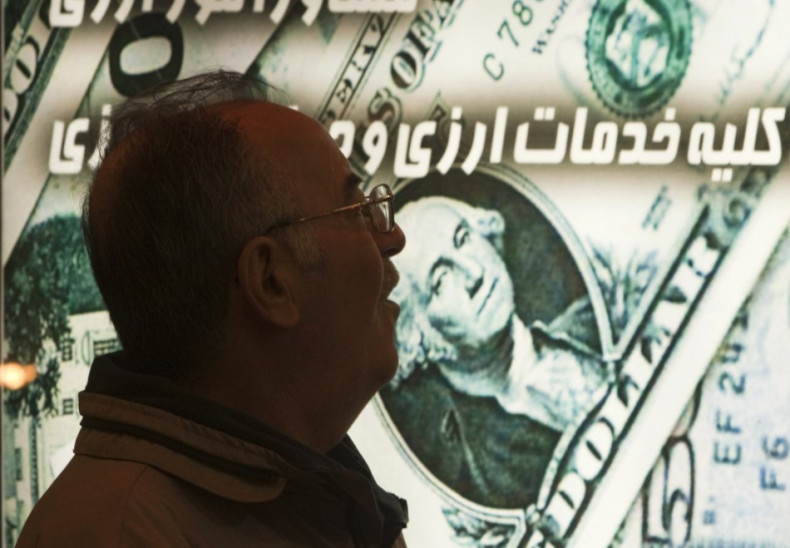 An Iranian man walks past a currency exchange shop in northern Tehran