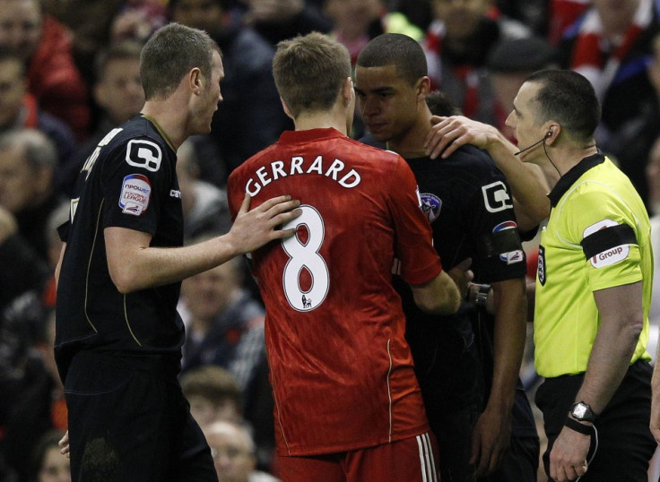 Oldham Athletic&#039;s Adeyemi is calmed down by Liverpool&#039;s Gerrard and referee Swarbrick after a fan shouted abuse at him during their FA Cup soccer match in Liverpool
