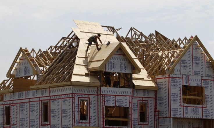 A builder works on the the roof of a new home