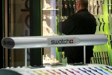 A man stands at a Swatch watch store at Zurich central station