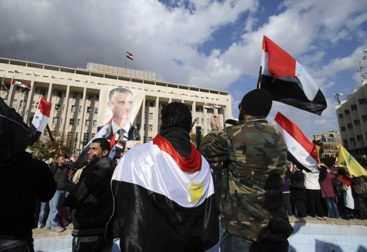 Supporters of Syria&#039;s President Bashar al-Assad carry Syrian flags