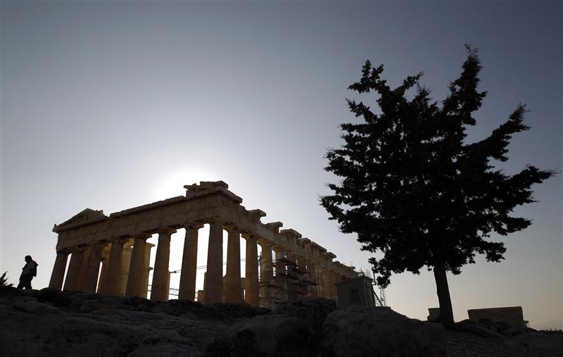 A tourist walks in front of the Parthenon temple at the Acropolis in Athens