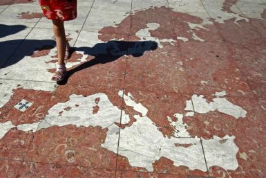 A woman walks on a map of Europe, which is part of a marble world planisphere, in Lisbon August 14, 2011.