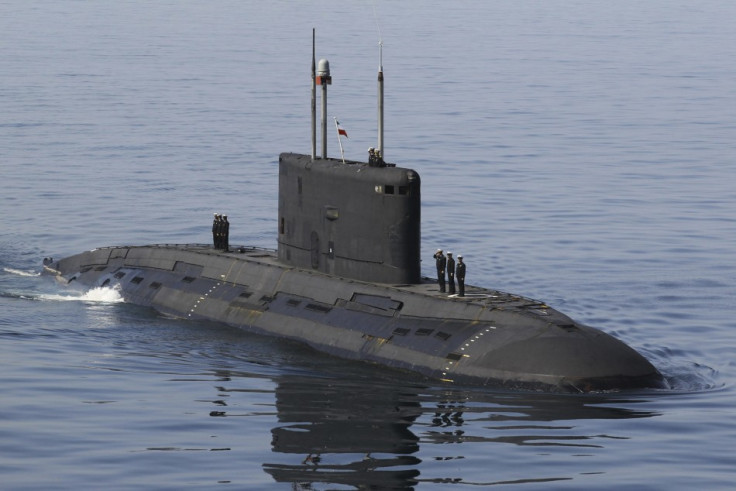 Iranian military personnel stand on a submarine during a naval parade