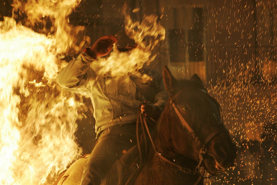 Flames cover a mans face as he races through the fire at the Luminarias festival in San Bartoleme de los Pinares