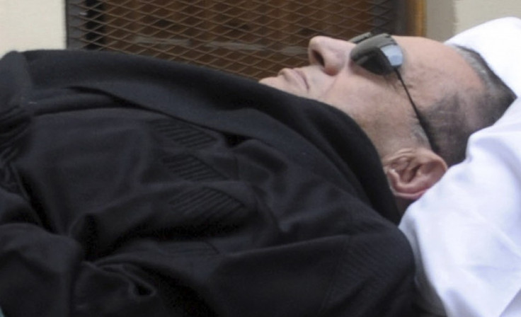Former Egyptian President Hosni Mubarak is seen on a stretcher outside the courthouse where he is standing trial