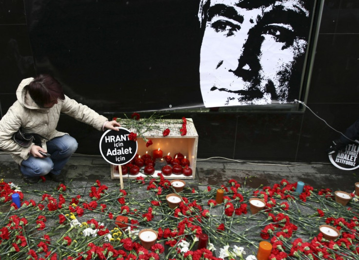 A protester leaves a banner next to the portrait of Hrant Dink in front of the office of the Agos newspaper