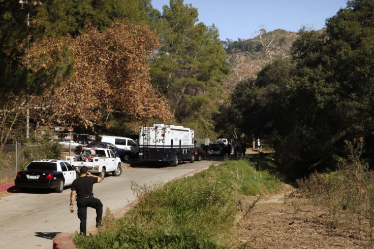 Los Angeles County coroners and Los Angeles police officers are seen at the crime scene in Bronson Canyon (Reuters)