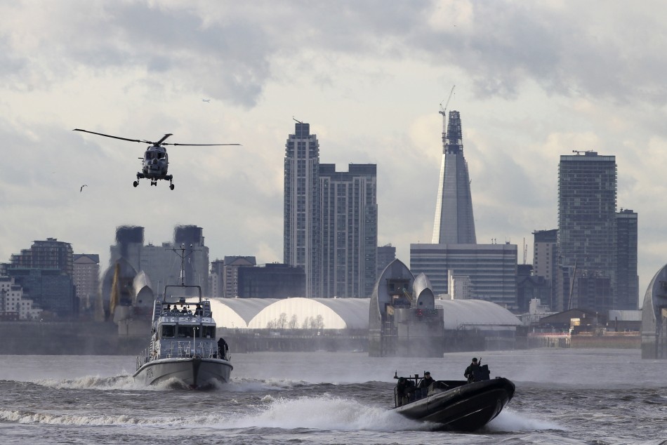A helicopter watches over two boats