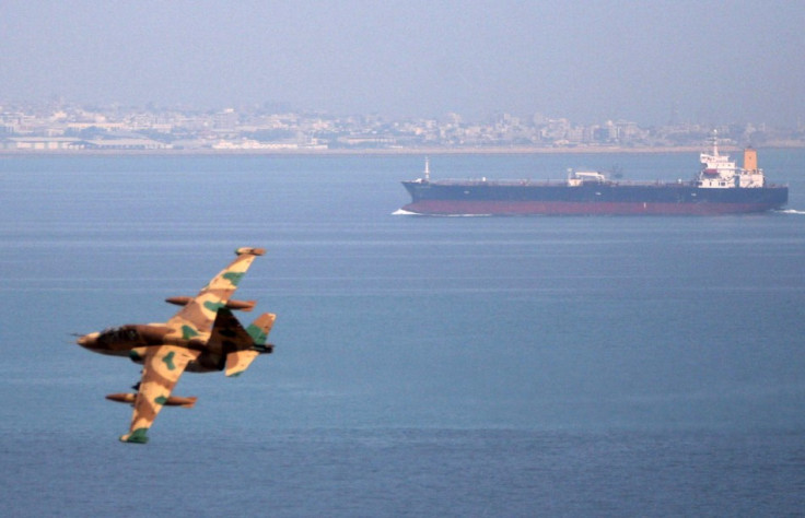 Iranian military fighter plane flies past oil tanker during naval manoeuvres in Persian Gulf and Sea of Oman