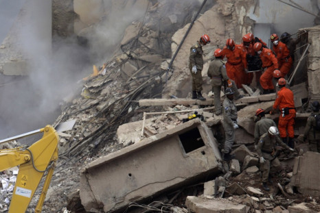 Firefighters carry the body of a victim among the debris of a collapsed building in Rio de Janeiro