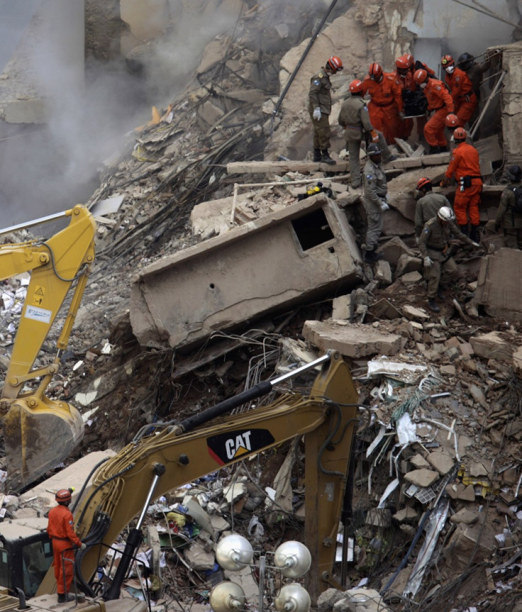 Firefighters carry the body of a victim among the debris of a collapsed building in Rio de Janeiro