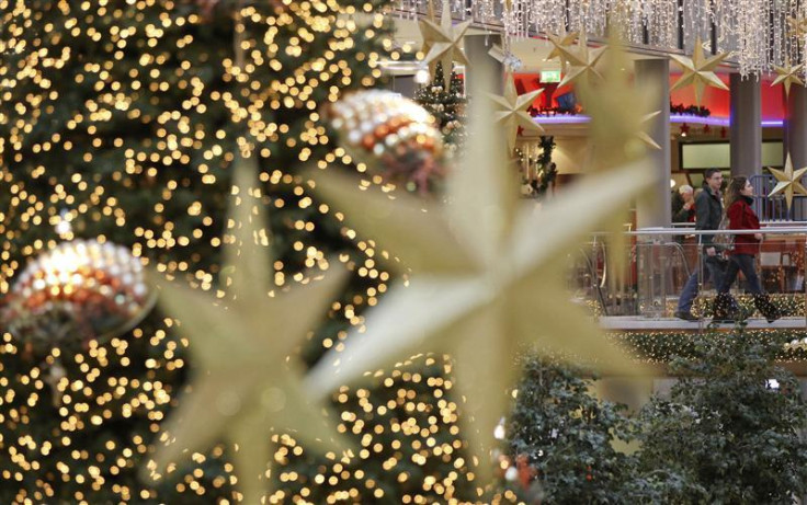 Shoppers walk among illuminated Christmas decorations in a shopping mall at Berlin&#039;s Potsdamer Platz