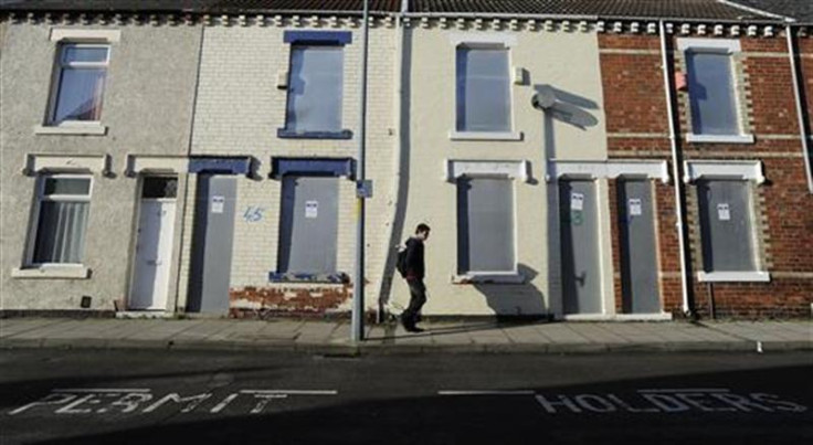 A pedestrian walks past boarded up houses on Coral Street in Middlesbrough, northern England