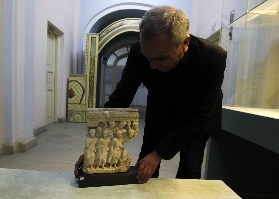 An Afghan specialist displays an ancient pre-Islamic sculpture that was returned to Afghanistan at the Afghan National Museum in Kabu