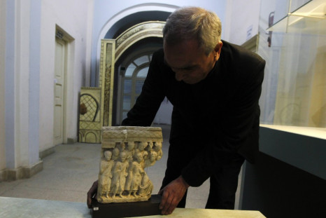 An Afghan specialist displays an ancient pre-Islamic sculpture that was returned to Afghanistan at the Afghan National Museum in Kabu