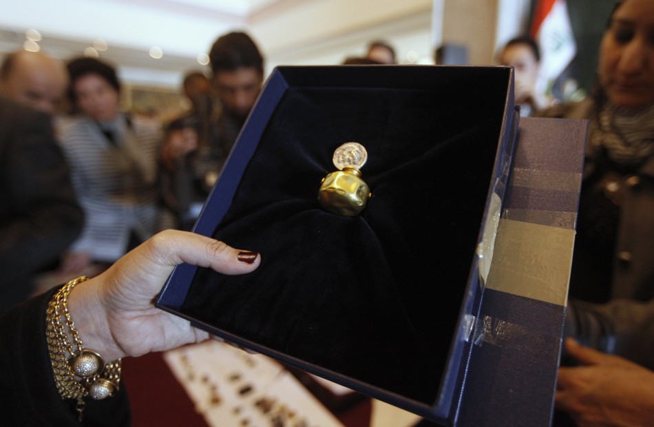 An employee displays a recovered tiny gold jar, dating to 4,500 BC at the Iraqi Ministry of Foreign Affairs headquarters in Baghdad