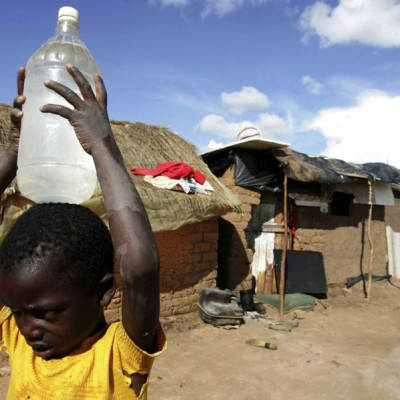 A boy carries a container of water in the suburb of Epworth in Zimbabwe's capital, Harare
