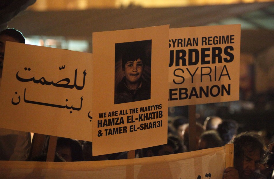 Protesters carry placards and poster of Syrian child Hamza al-Khatib shout anti-Syrian regime slogans