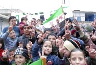 Children flash victory signs during a rally against Syria's President Bashar al-Assad in Jerjenaz, near Idlib