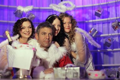 Women dressed as Christmas angels pose with wax figure of US actor Clooney at the German 'Madame Tussauds' in Berlin