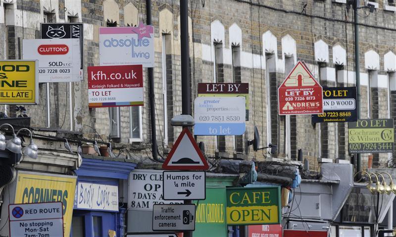 Property letting and sale signs are seen above shops in south London