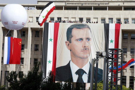 A Russian and a Chinese flag hang from a balloon during a rally of supporters of Syrian President Bashar al-Assad at al-Sabaa Bahrat square in Damascus