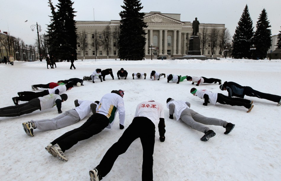 Belarusian men do physical exercises at the main square of the town of Molodechno