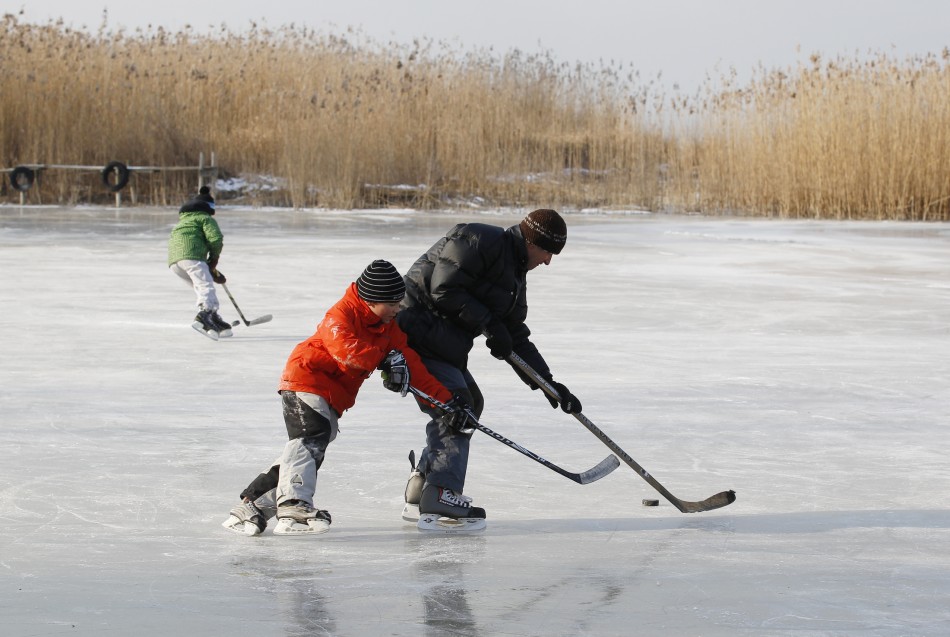 People play ice hockey on a frozen part of the lake Neuchatel in Cudrefin