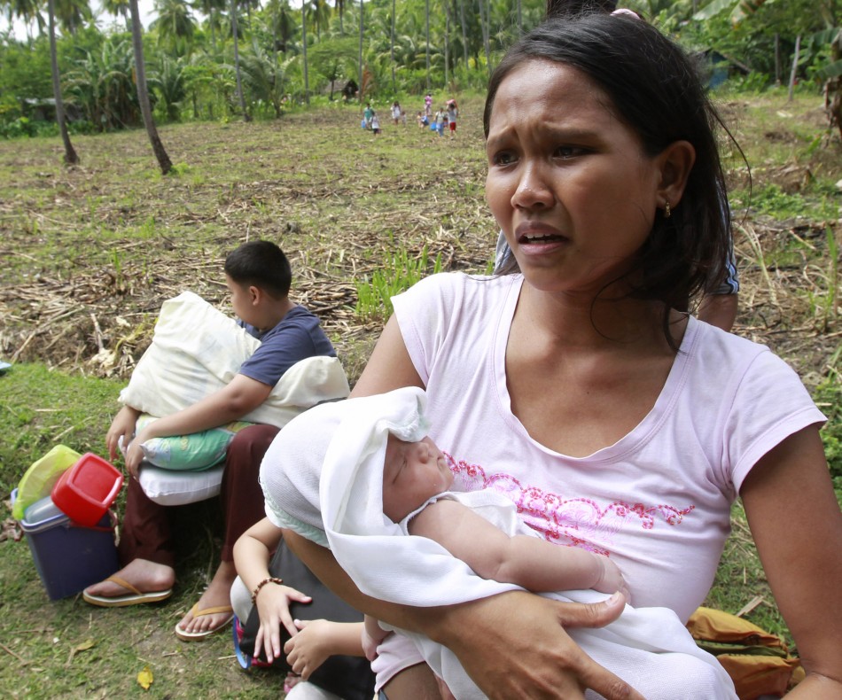 A woman carries her baby during evacuation