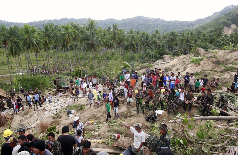 Residents and soldiers gather at the site of a landslide