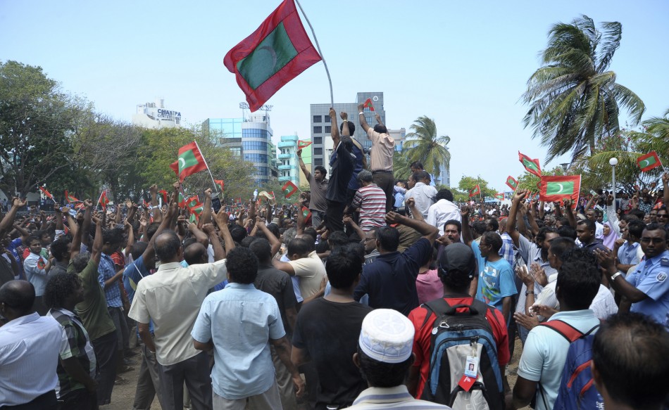 Supporters of opposition parties hold Maldives national flags as they celebrate after Maldives President Nasheed resigned in Male