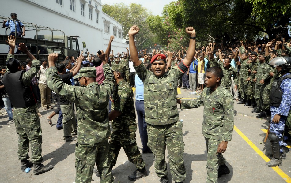 Maldives soldiers raise their hands and shout slogans in Male