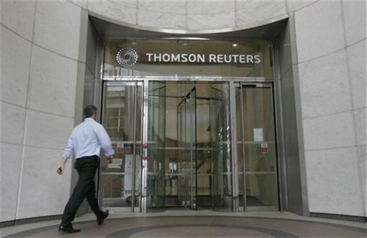 A worker enters the Thomson Reuters building in the Canary Wharf financial district of London