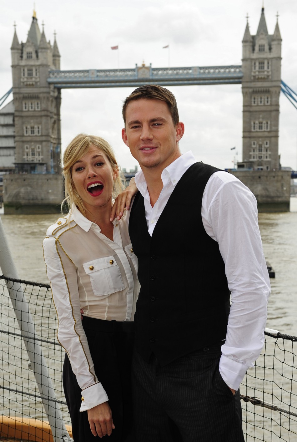 British actress Sienna Miller and U.S. actor Channing Tatum pose for photographers during a photocall to promote their new film G.I. Joe, in front of Tower Bridge, on HMS Belfast on the River Thames in London